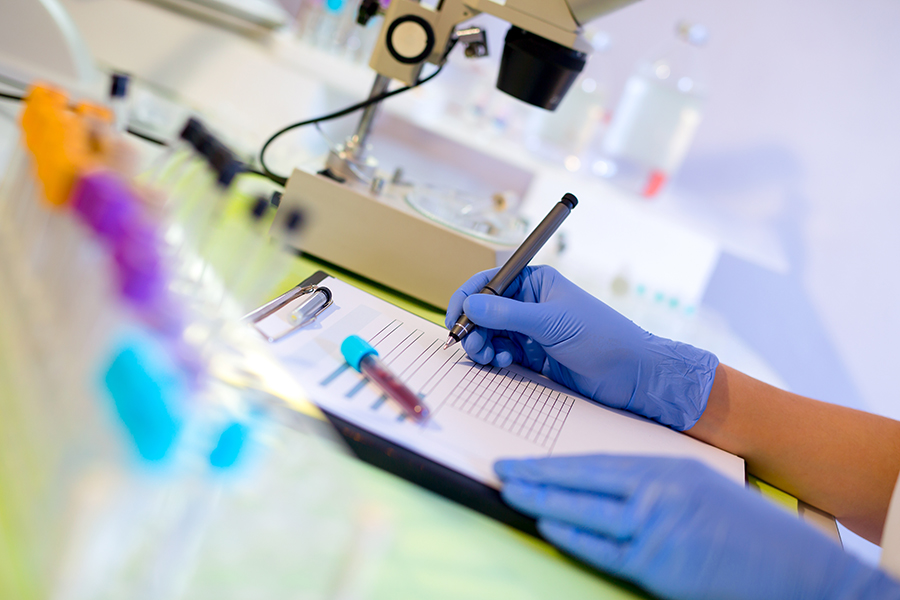 Woman working in a laboratory. He writes with a felt pen. Selective focus