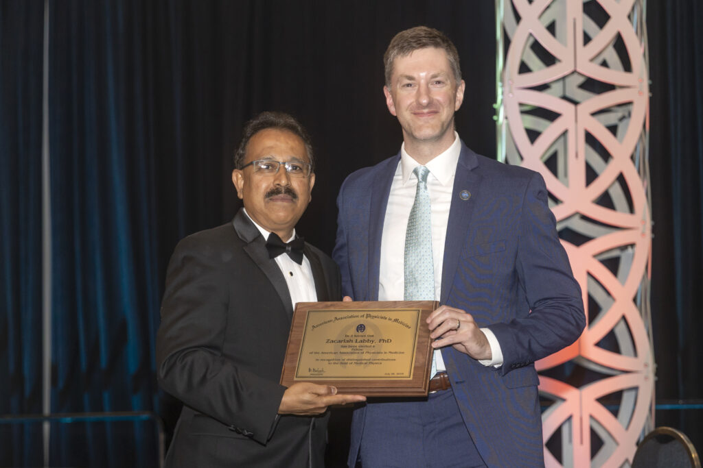 Zac Labby and M Mahesh pose with AAPM Fellow plaque